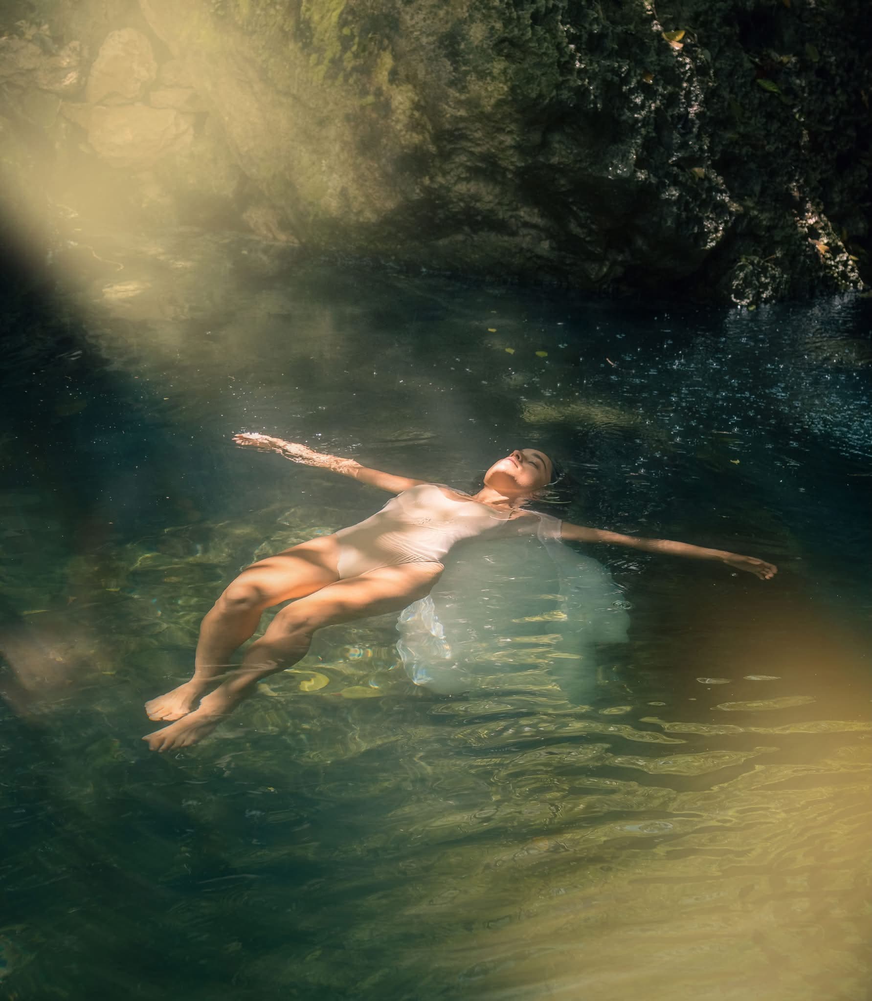 A woman floating in a cenote at Atlantis Spa